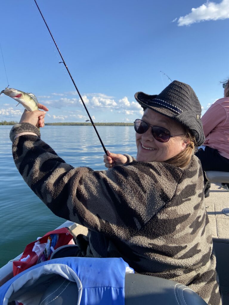 April Weberg catching fish on woman lake