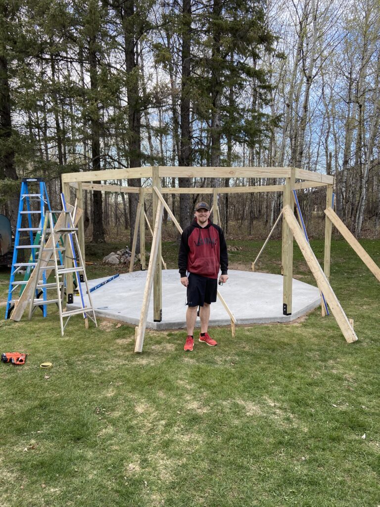 A picture of my son Josh after we got the main beams up, he was a big help.